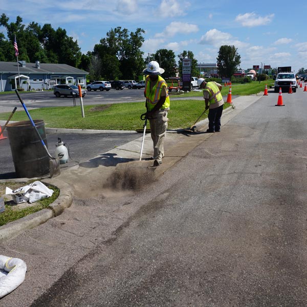 A worker cleaning oil spill in Raleigh & Fayetteville, NC