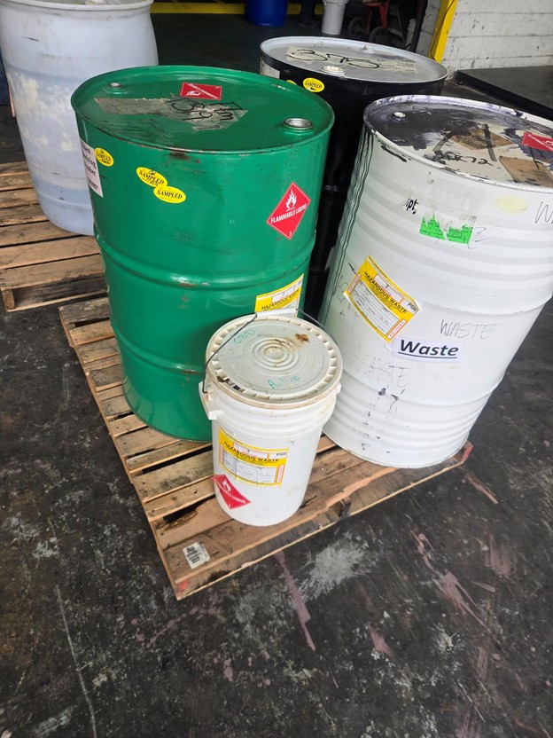 Labeled waste drums stored on a pallet for solid waste management in Raleigh, NC